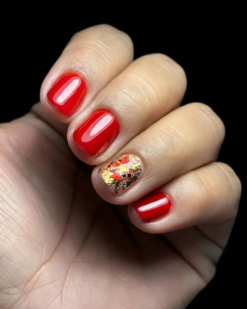 Manicura roja con detalle de hoja de oro