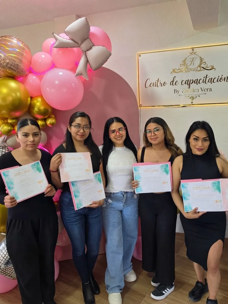 Alumnas mostrando sus diplomas al terminar su formación